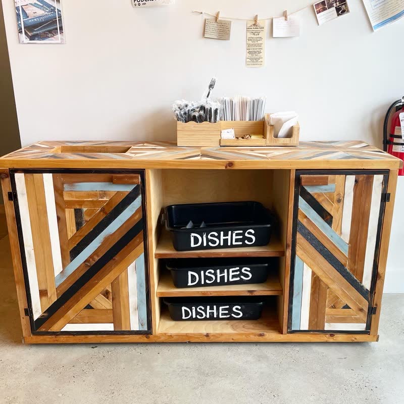A herringbone bussing station built from reclaimed wood, serving a local café