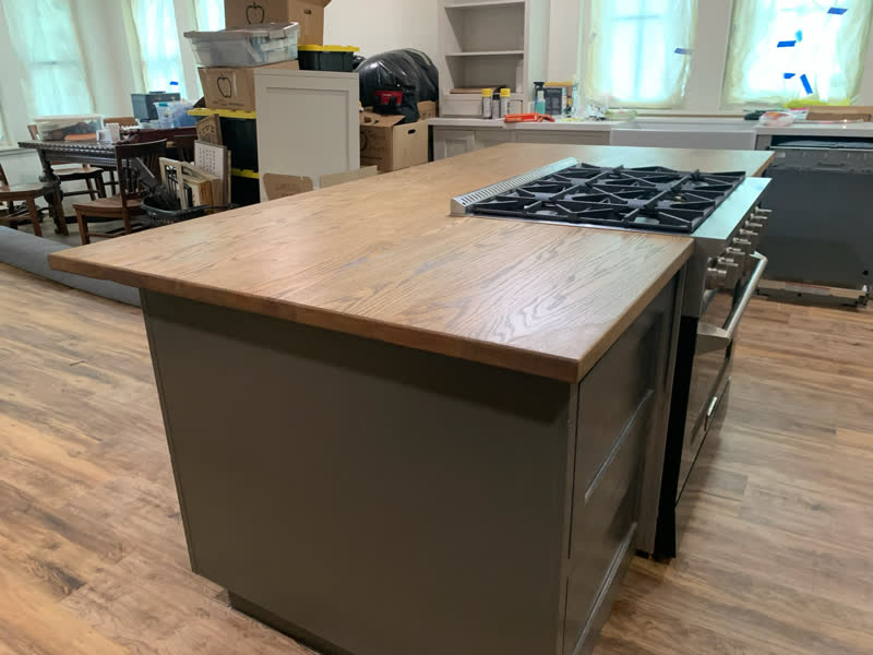 A custom oak kitchen island top with a gas cooktop, installed in a client's home